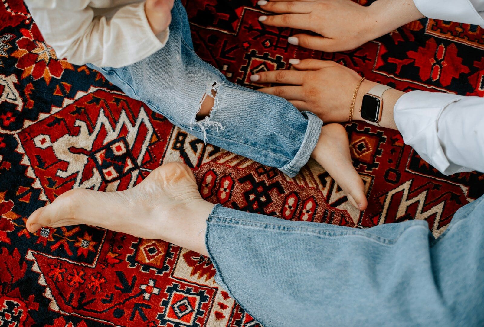 two people sitting on top of a red rug